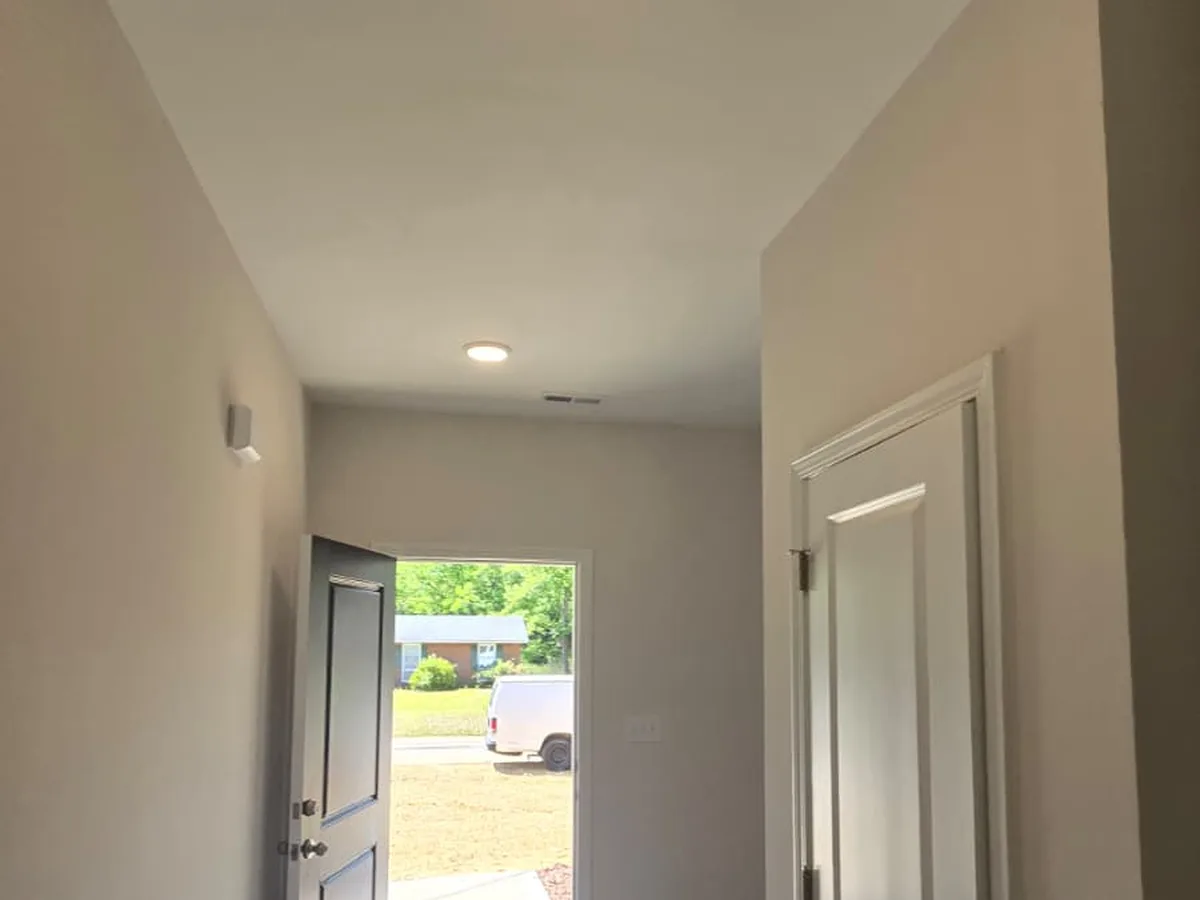 Painted hallway with a white door frame and the entry door open